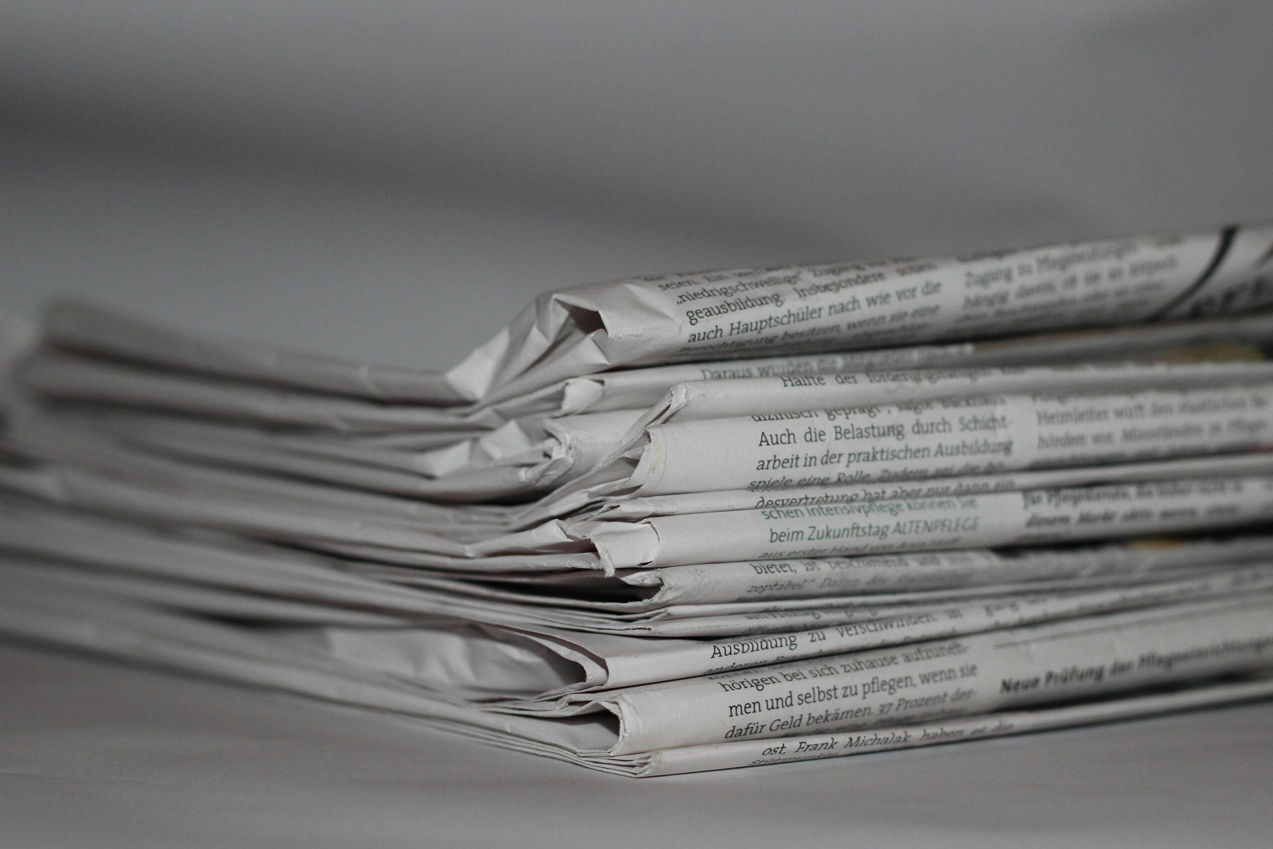 A close-up image of folded newspapers, perfect for news or journalism themes.